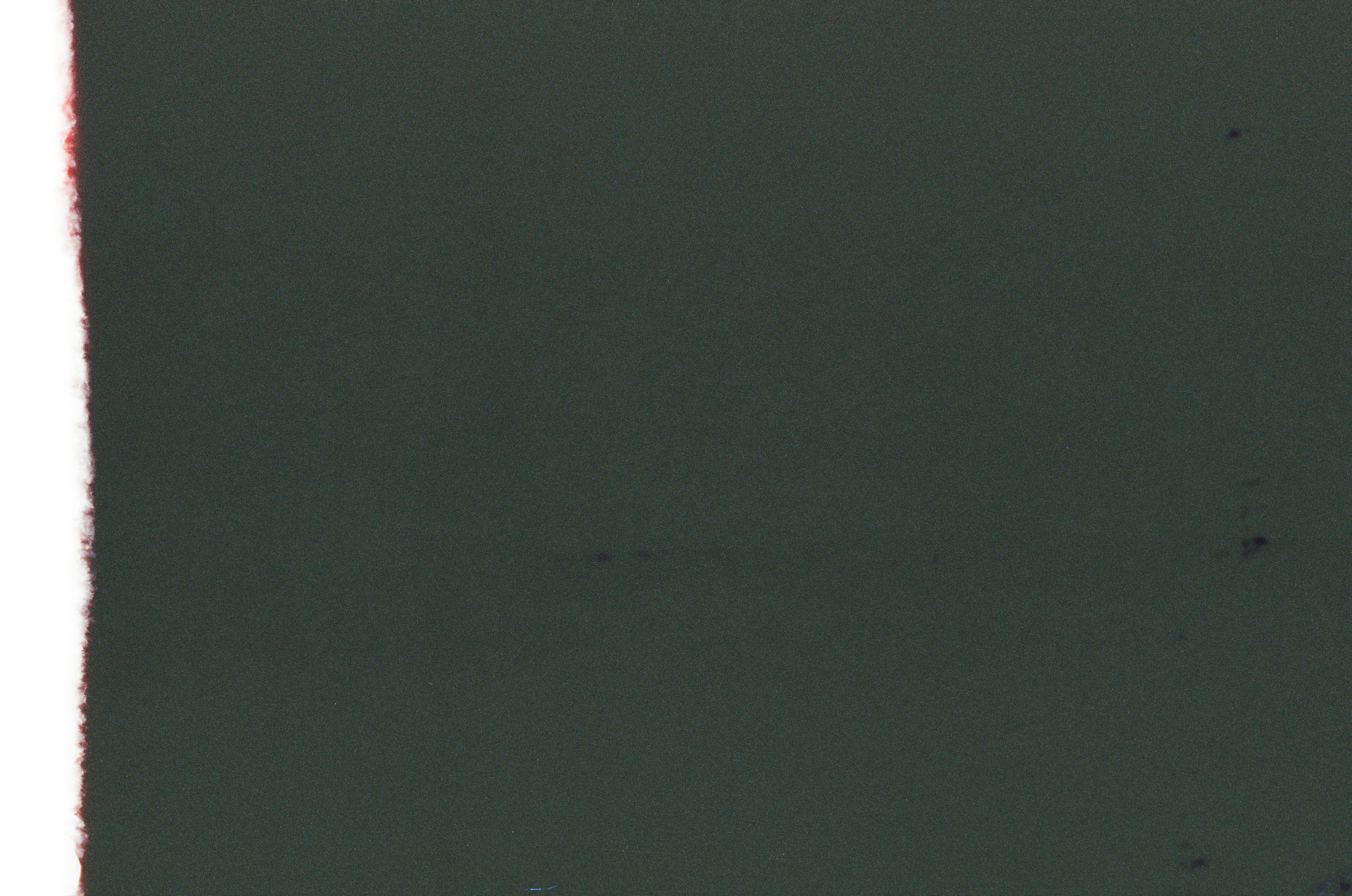 A nearly black, dark green frame with a thin strip of red and white light flare along its left edge.