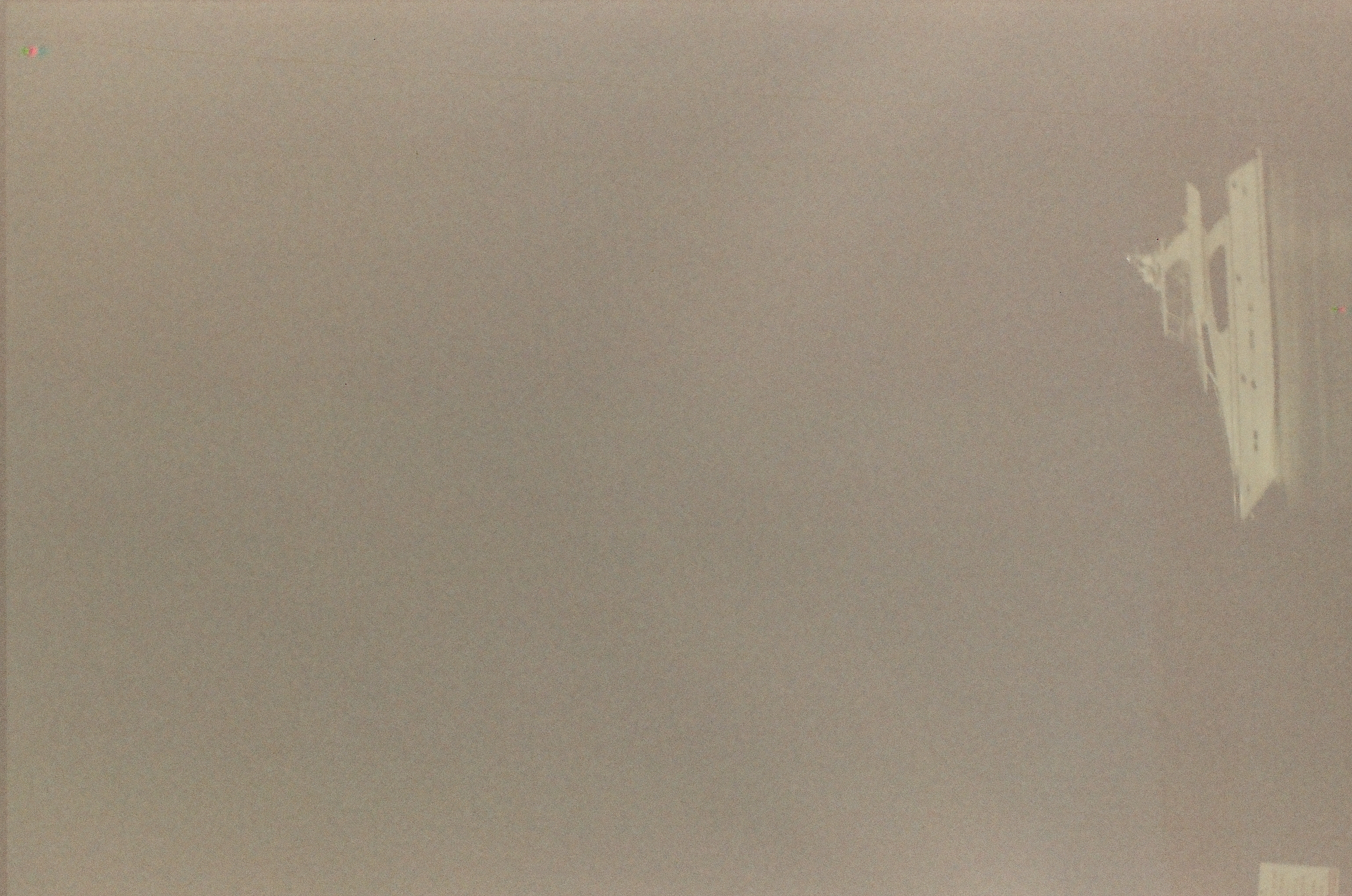 A white motor yacht sits low in a tall gray expanse where water and sky have no visible boundary.
