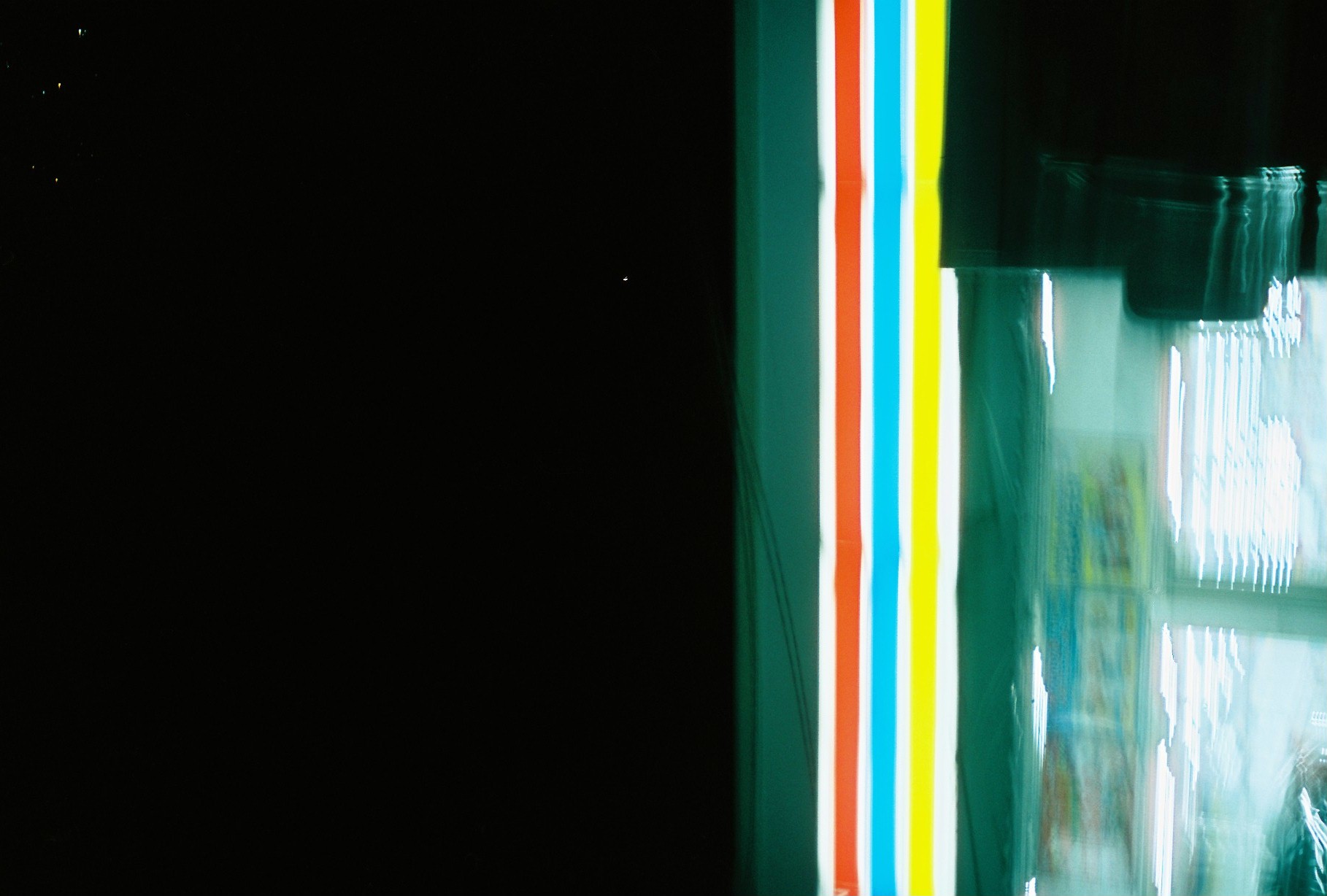 Colored horizontal bands divide a large black upper field from a bright blurred lower area and dark rectangle at right.