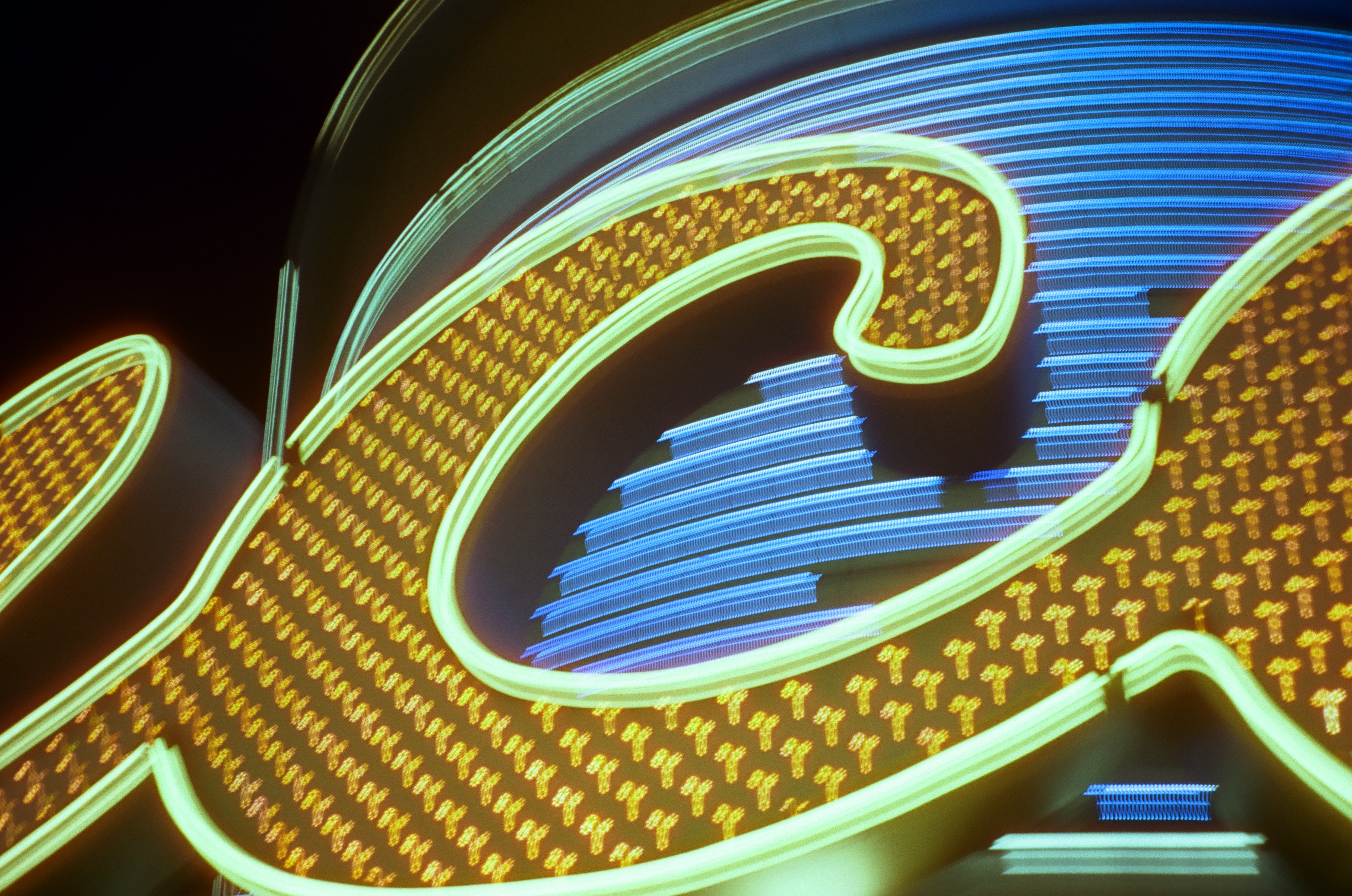 A large gold cursive letterform outlined in pale neon curls around an open space filled with layered blue horizontal light streaks.