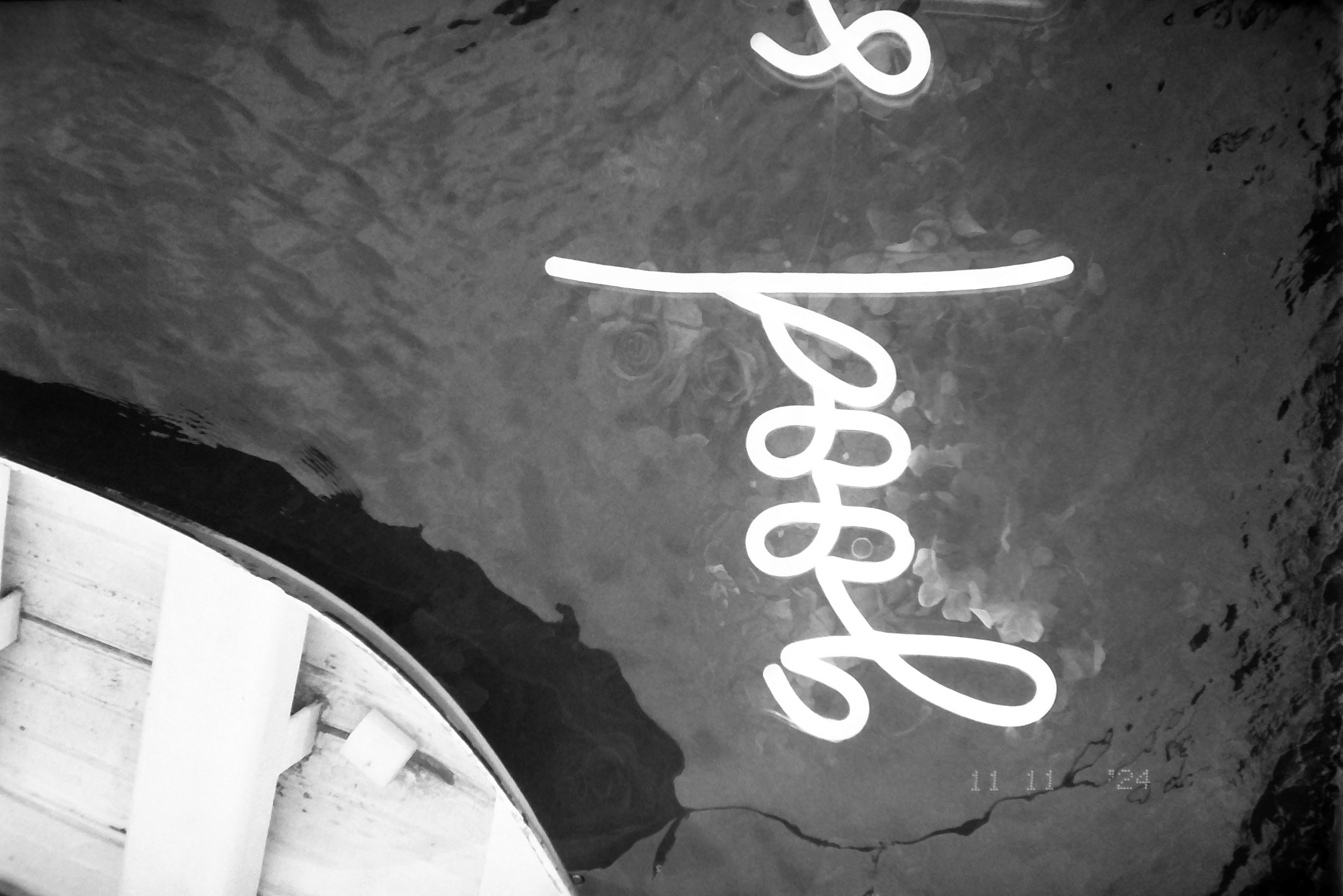 Glowing cursive script spelling 'good' floats on dark, rippled water beside the wooden bow of a boat visible at upper left.